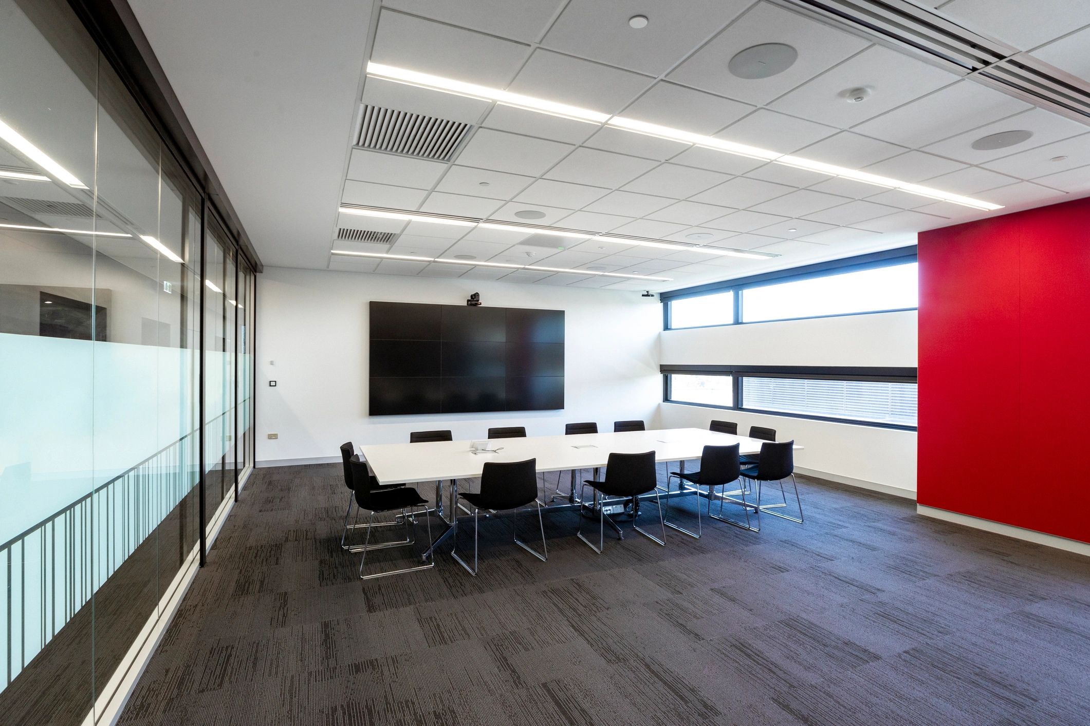 Modern executive meeting space with digital presentation wall
