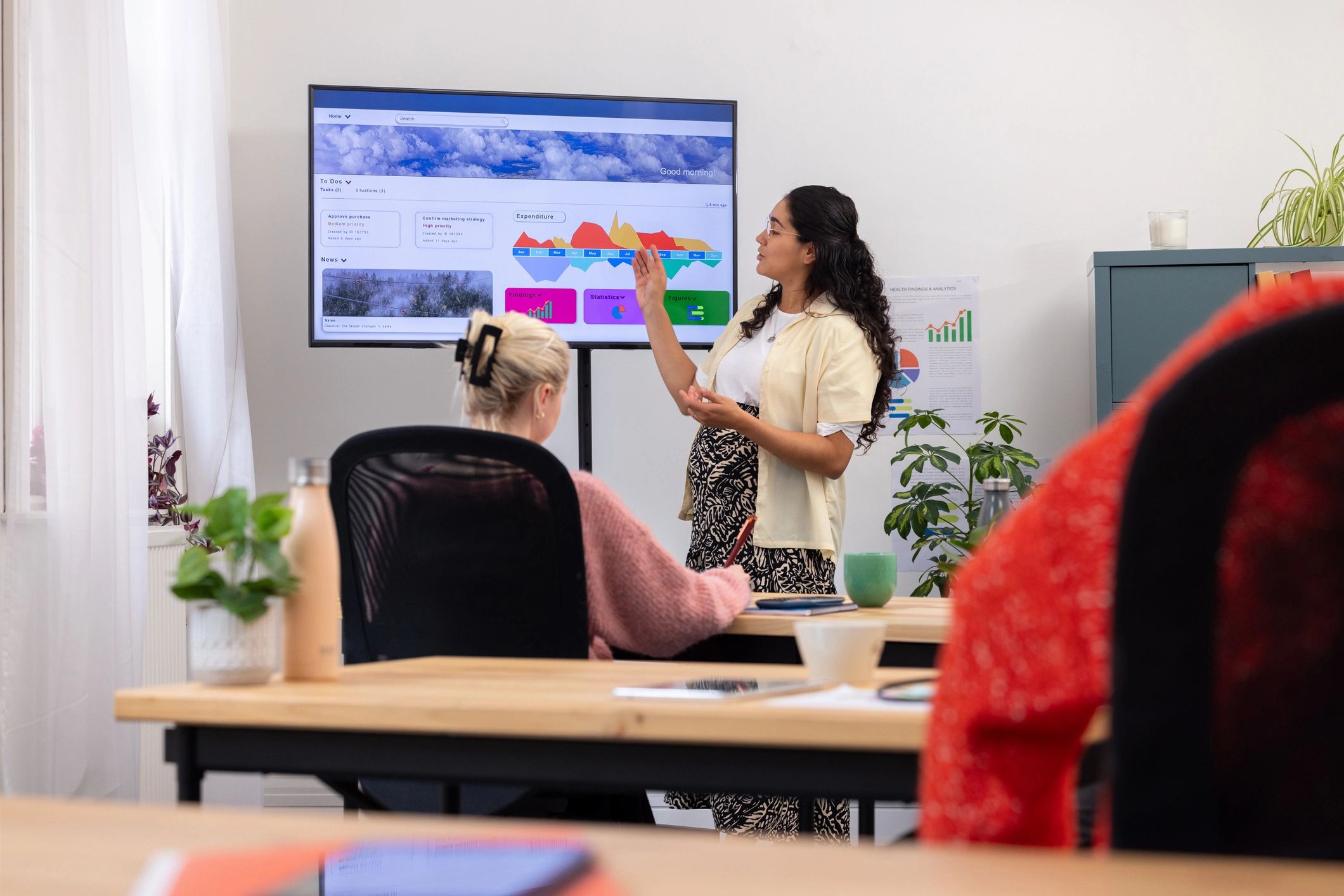 Consultant presenting analytics and KPI visuals to a team